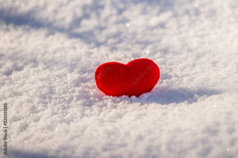 the red heart lies on the snow. The concept of Valentine's day