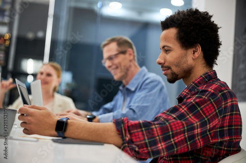 Smiling afro american man working with colleagues in office
