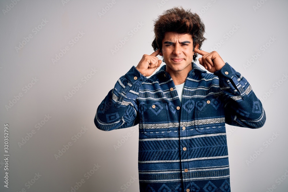 Young handsome man wearing casual shirt standing over isolated white background covering ears with fingers with annoyed expression for the noise of loud music. Deaf concept. Young handsome man wearing casual shirt standing over isolated white background covering ears with fingers with annoyed expression for the noise of loud music. Deaf concept.