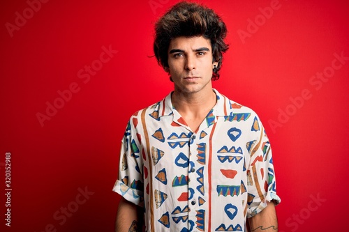 Wallpaper Mural Young handsome man on vacation wearing summer shirt over isolated red background Relaxed with serious expression on face. Simple and natural looking at the camera. Torontodigital.ca