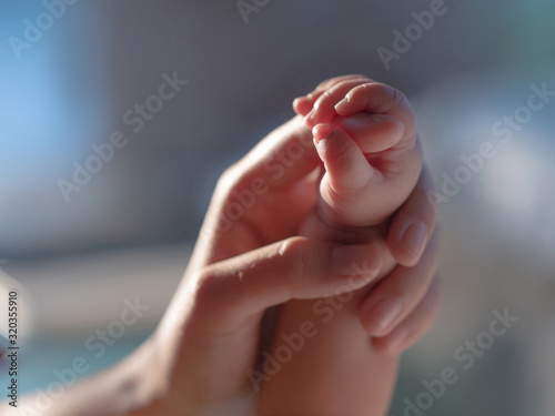 Newborn baby is holding the mother's hand