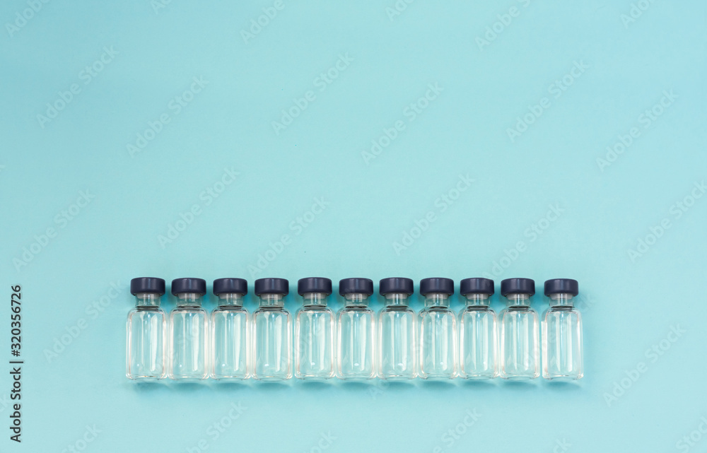 Medicine in vials, ready for vaccine injection on blue background. Horizontal composition. Front view. Medicine in vials, ready for vaccine injection on blue background. Horizontal composition. Front view.
