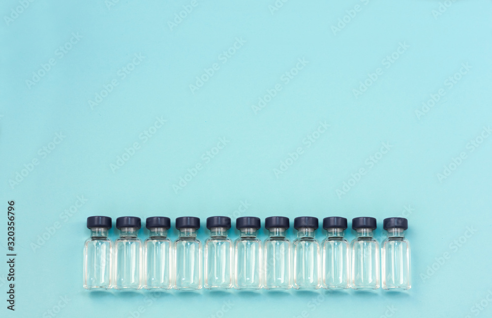 Medicine in vials, ready for vaccine injection on blue background. Horizontal composition. Front view. Medicine in vials, ready for vaccine injection on blue background. Horizontal composition. Front view.
