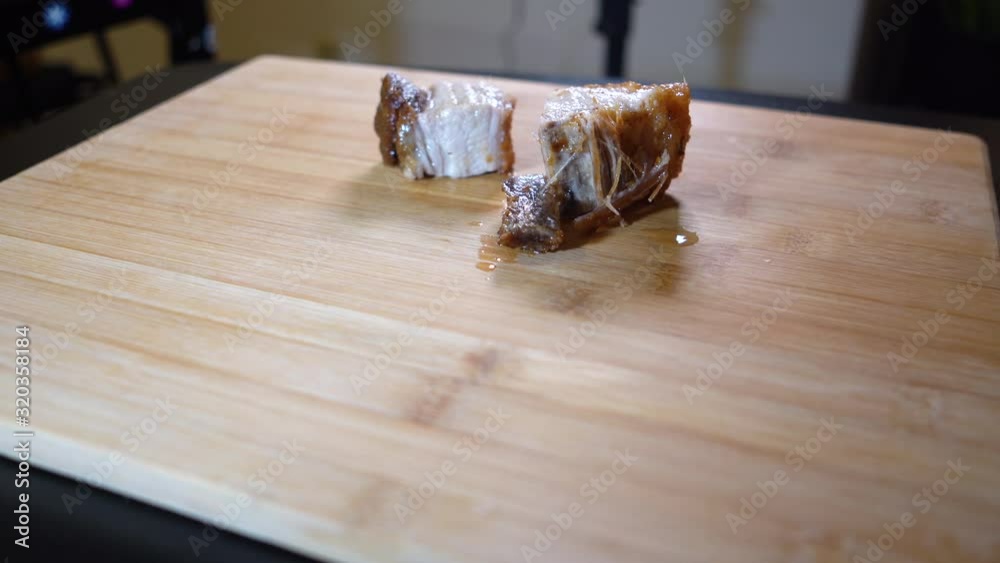 Placing pork fat and skin on chopping board. Newly cooked pork lechon