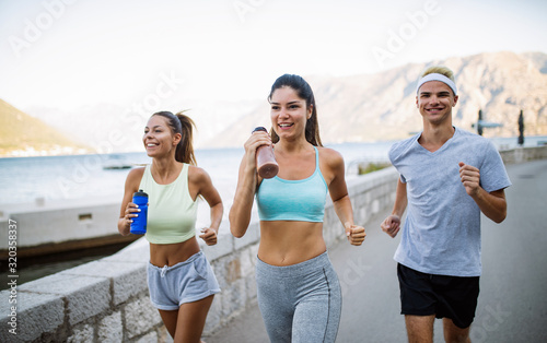 Outdoor portrait of group of friends running and jogging in nature