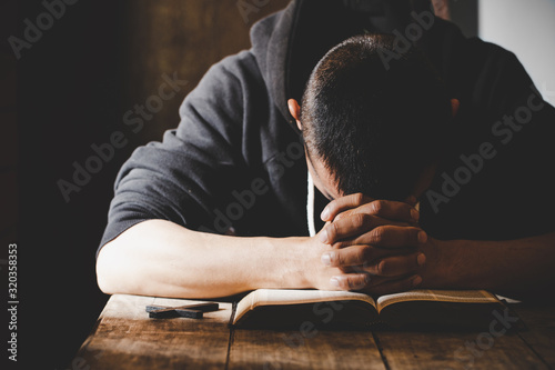 Religious young man praying to God in the morning photo