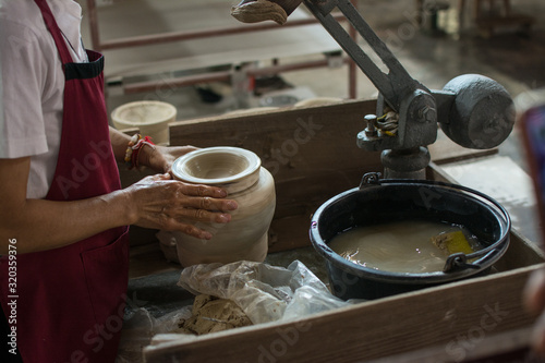 hands working clay on potter's wheel, Lampang in Thailand