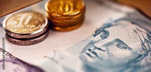 Brazilian money in close up. One hundred reais bill and Brazilian coins, concept of savings or savings.