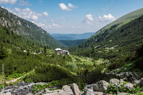 Mountain landscape from the beautiful Bulgarian Rila Mountain at sunny summer day, the green Malyovitsa Valley and Malyovitsa Hut, top view.