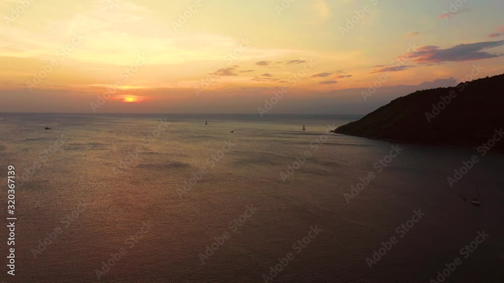Orange sunset over the sea. The sun is setting over the horizon. Evening view of the mountains and sea. Big Cumulus clouds in the sky. Beautiful view from above. Orange sunset over the sea. The sun is setting over the horizon. Evening view of the mountains and sea. Big Cumulus clouds in the sky. Beautiful view from above.