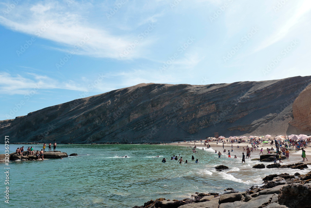 Playa La Mina, picturesque view of the beach next to the visitors bathers during the summer. Ica-Peru