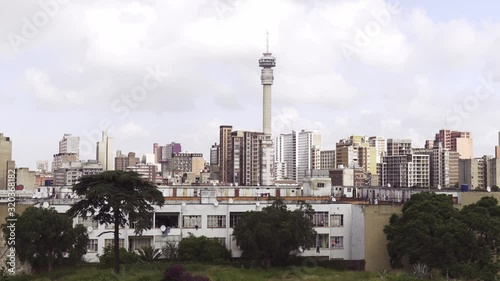 The Johannesburg South Africa skyline with Hillbrow Tower visible at the center shot from a hill. High angle, Pan right, Full shot. photo