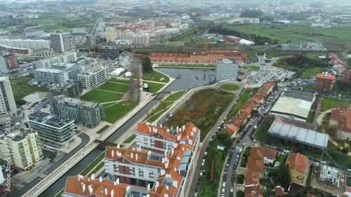 Aerial view of city center of Aveiro, Portugal. View of buildings with orange roof and cars crossing the streets. Drone footage pan from left to right.