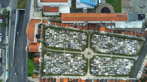 Aerial view of city center of Aveiro, Portugal. View top down of the cemetery and buildings with orange roof. Cars crossing the streets. Drone footage tilt up