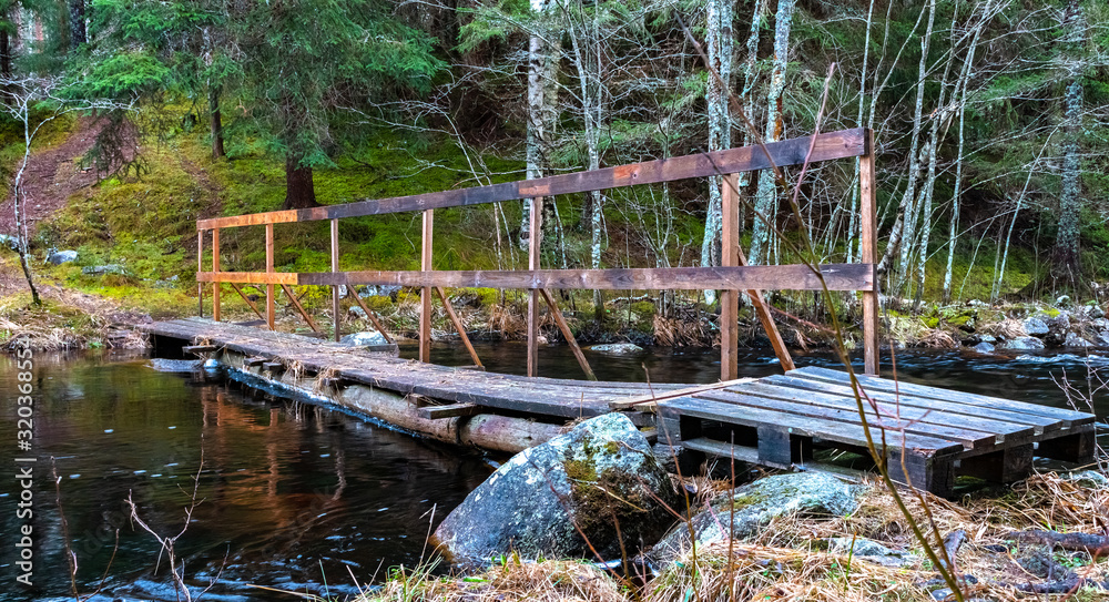 Wooden bridge over a river in a forest in Sweden