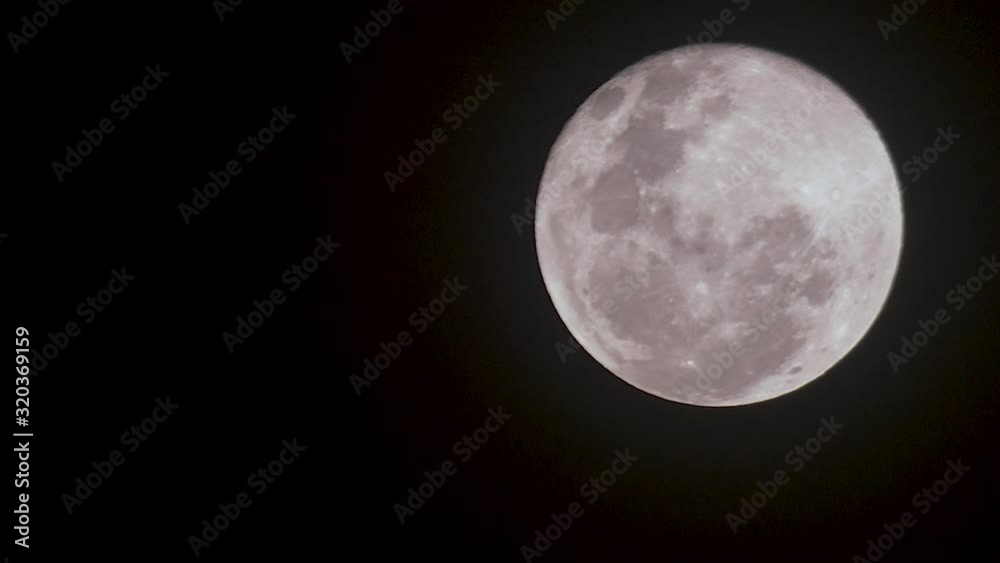 The beautiful full moon rising in the heavens - time lapse