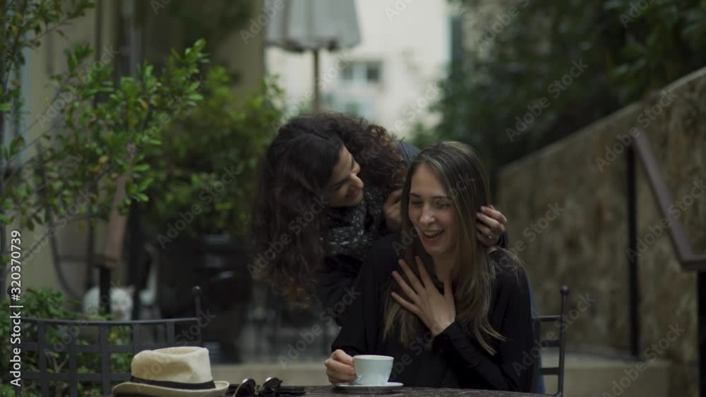 Beautiful young woman sneaking behind her best friend and surprising her with a visit at a coffee place. hugging each other and feeling excited. 4k Beautiful young woman sneaking behind her best friend and surprising her with a visit at a coffee place. hugging each other and feeling excited. 4k