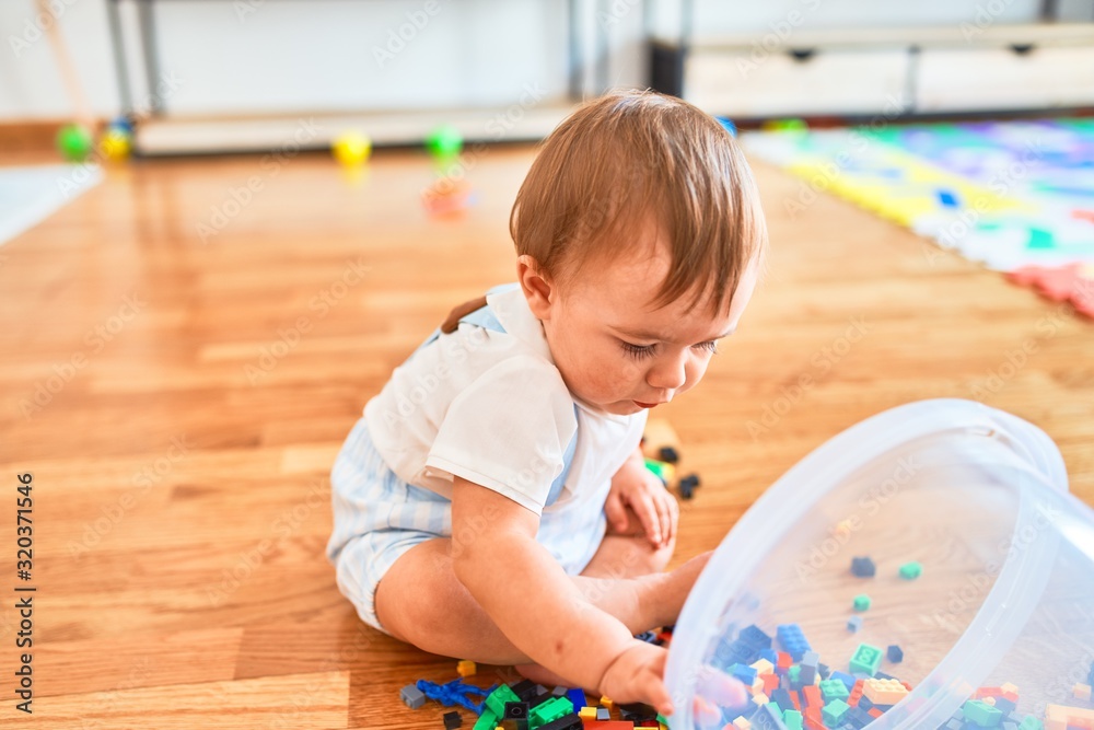 Adorable toddler playing around lots of toys at kindergarten Adorable toddler playing around lots of toys at kindergarten