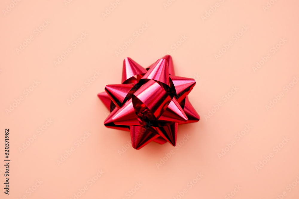 Red gift bow on a pastel pink background. Top view. Copy space. Red gift bow on a pastel pink background. Top view. Copy space.