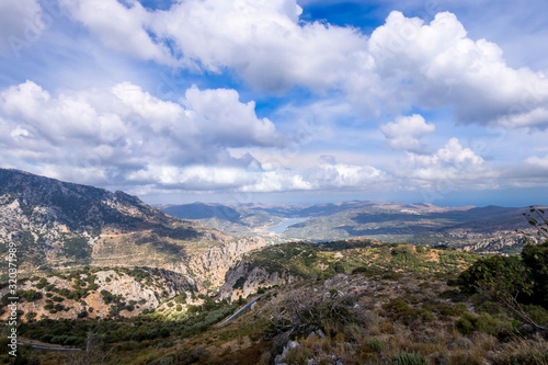 Mountains on the island of Crete on a clear sunny summer day with a cloudy sky and lake. photo