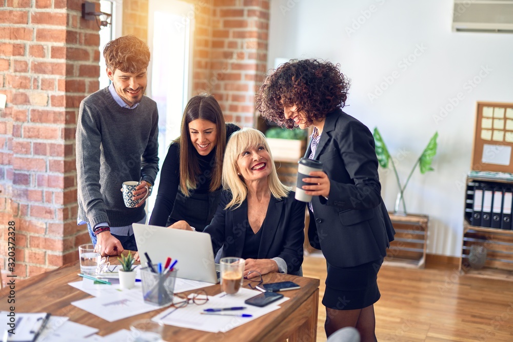 Group of business workers smiling happy and confident. Working together with smile on face using laptop at the office Group of business workers smiling happy and confident. Working together with smile on face using laptop at the office