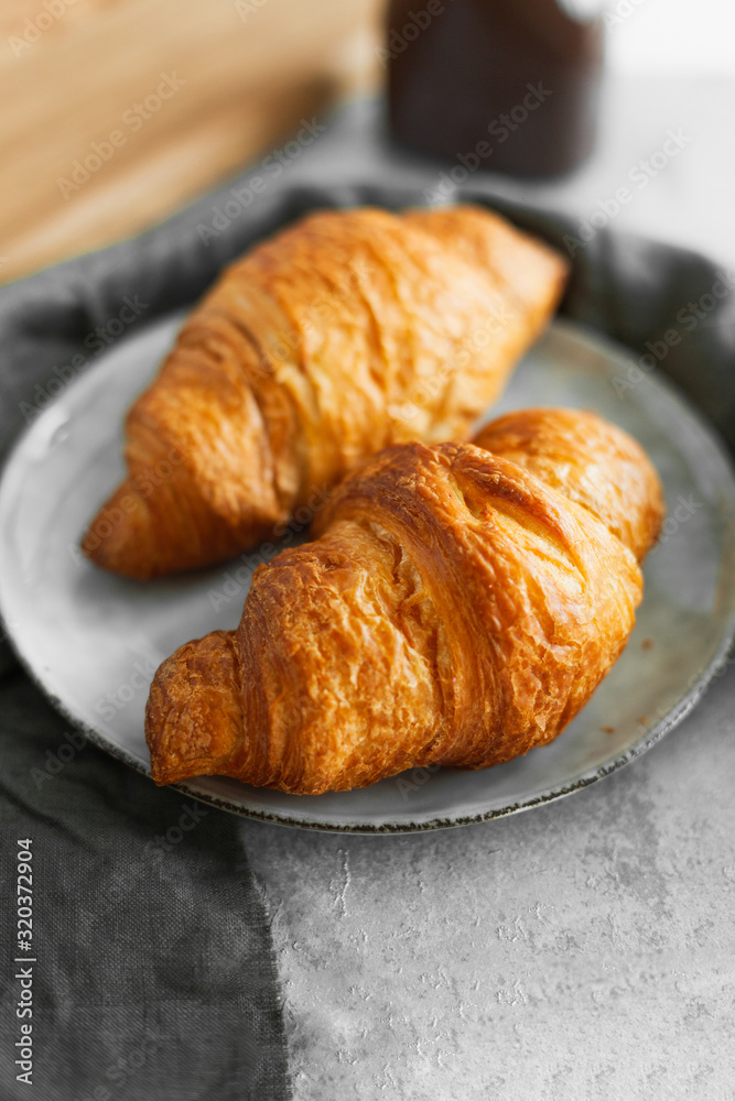 Two croissants with chocolate paste and nuts on a table