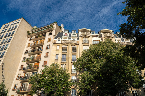 Parisian architecture high rise complex with apartments and balconies on sunny day