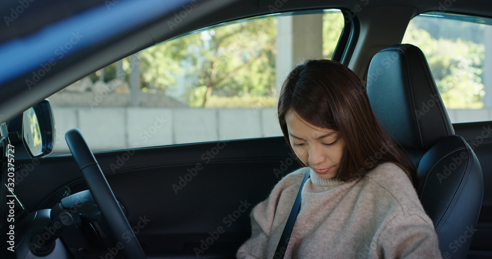 Woman fasten the seat belt inside a car