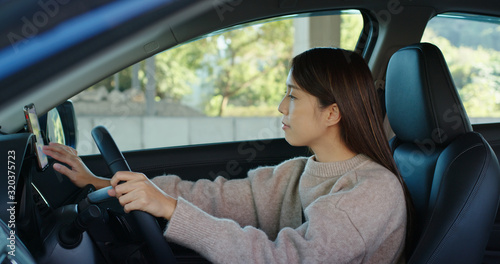 Woman set gps location on cellphone inside a car © leungchopan