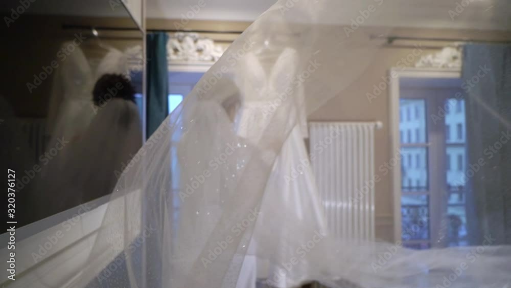 Bride with long veil getting ready in the morning. Preparation before wedding ceremony, put on dress. Bride with long veil getting ready in the morning. Preparation before wedding ceremony, put on dress.