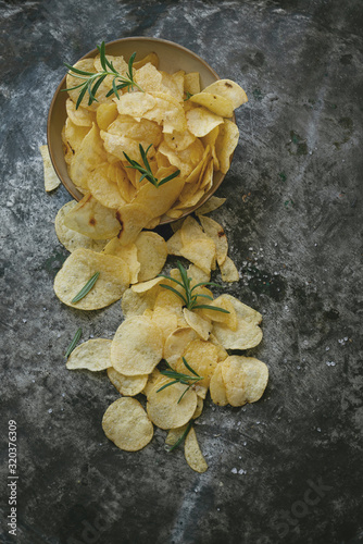 Crispy potato chips in the bowl with salt and seasonings
