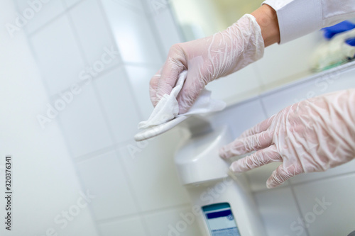 A nurse disinfects an item in a hospital room