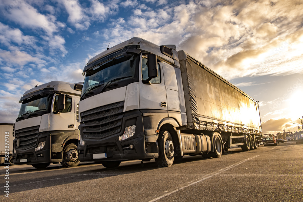 Trucks in a row with containers in the parking lot. Logistic and Transport concept Trucks in a row with containers in the parking lot. Logistic and Transport concept
