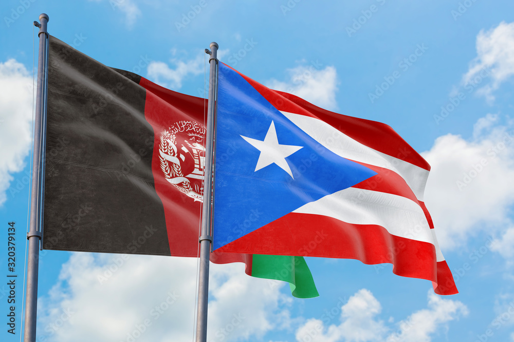Puerto Rico and Afghanistan flags waving in the wind against white cloudy blue sky together. Diplomacy concept, international relations.
