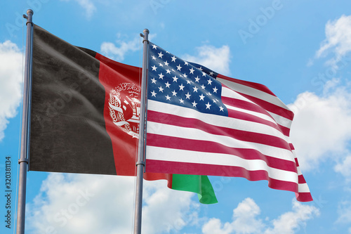 United States and Afghanistan flags waving in the wind against white cloudy blue sky together. Diplomacy concept  international relations.