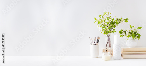 Home interior with decor elements. Spring flowers in a vase, office supplies on a light background