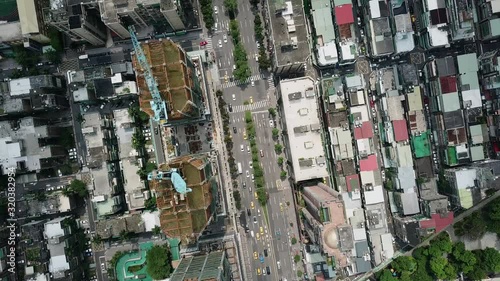 Top down aerial view of residential and commercial buildings in Taipei. Cars on the road and trees at the background. Spinning on the spot. photo