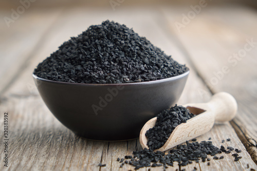 Black cumin or roman coriander seeds in bowl. Ingredient for cooking. Ayurveda treatment. photo