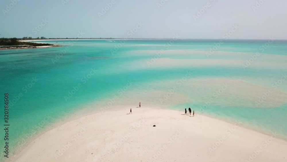 People on a white sandy beach in Providenciales in the Turks and Caicos archipelago. High angle aerial People on a white sandy beach in Providenciales in the Turks and Caicos archipelago. High angle aerial