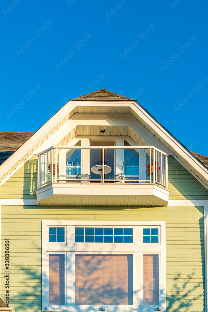 A perfect neighborhood. Houses in suburb at Summer in the north America. Top of a luxury house with nice window over blue and white sky.