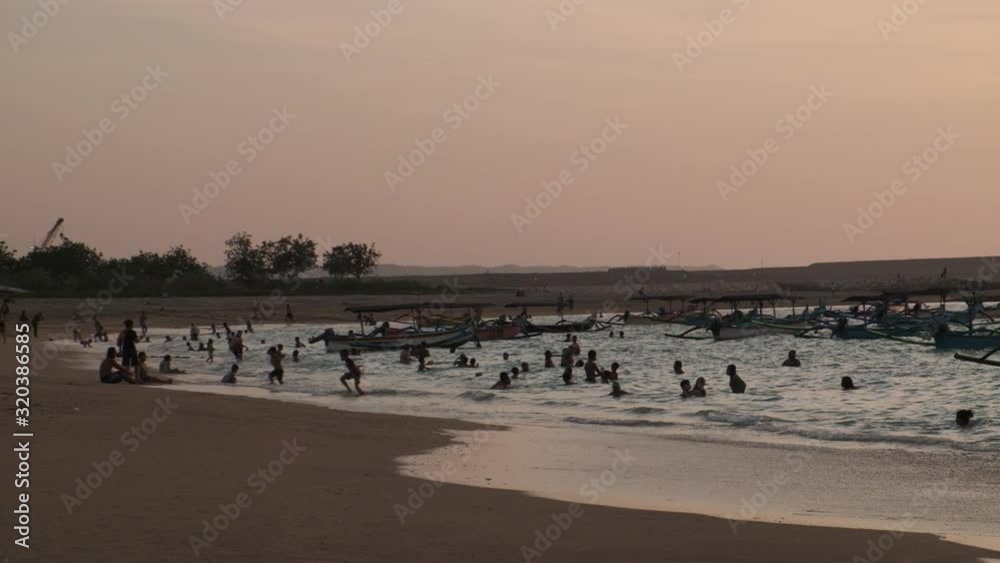 People bathing during sunset on the beaches of Kuta, Bali. People bathing during sunset on the beaches of Kuta, Bali.