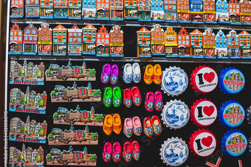 Traditional souvenirs from Amsterdam - fridge magnets, rows of Delftware porcelain, Dutch style houses, dutch wooden clogs, wooden tulips and windmill miniature, shop window store front, Netherlands