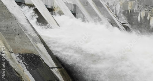 Slow motion shot of powerful water flowing out of a large dam