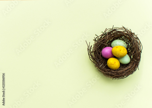 Easter eggs in a nest on a yellow background