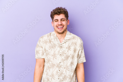 Wallpaper Mural Young blond curly hair caucasian man isolated laughs and closes eyes, feels relaxed and happy. Torontodigital.ca