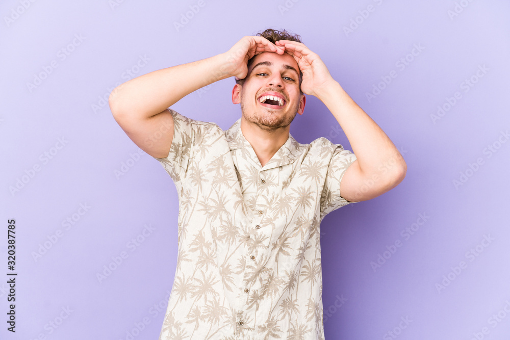 Young blond curly hair caucasian man isolated laughs joyfully keeping hands on head. Happiness concept. Young blond curly hair caucasian man isolated laughs joyfully keeping hands on head. Happiness concept.