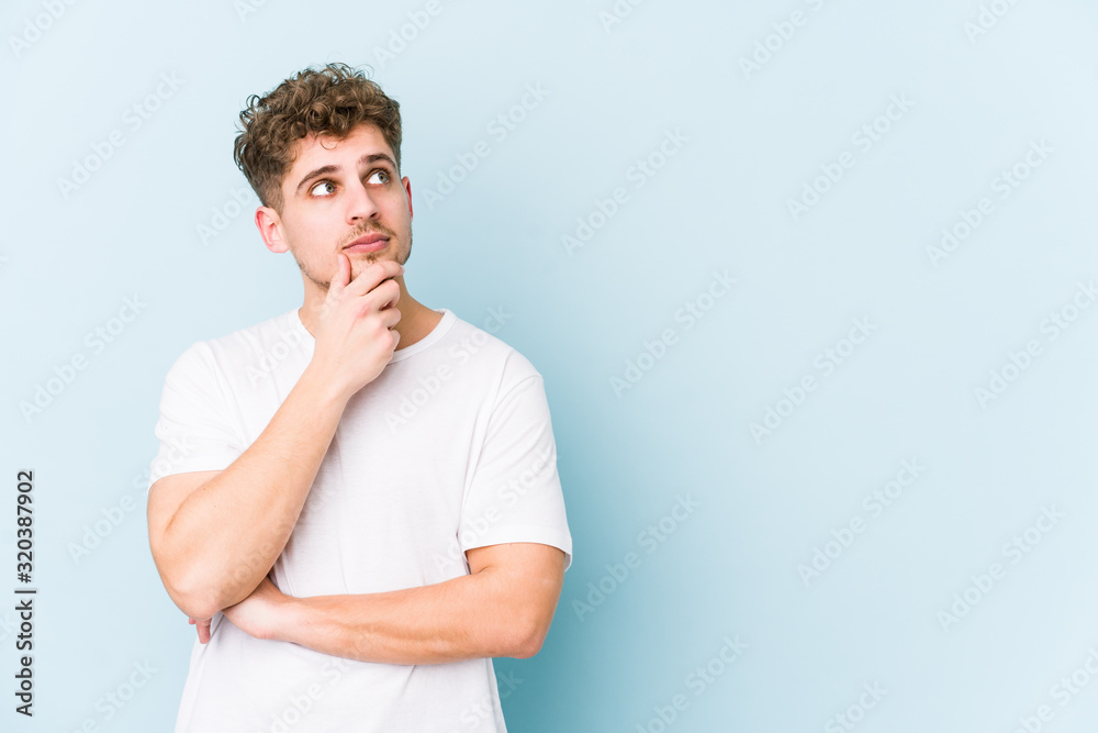 Young blond curly hair caucasian man isolated looking sideways with doubtful and skeptical expression. Young blond curly hair caucasian man isolated looking sideways with doubtful and skeptical expression.
