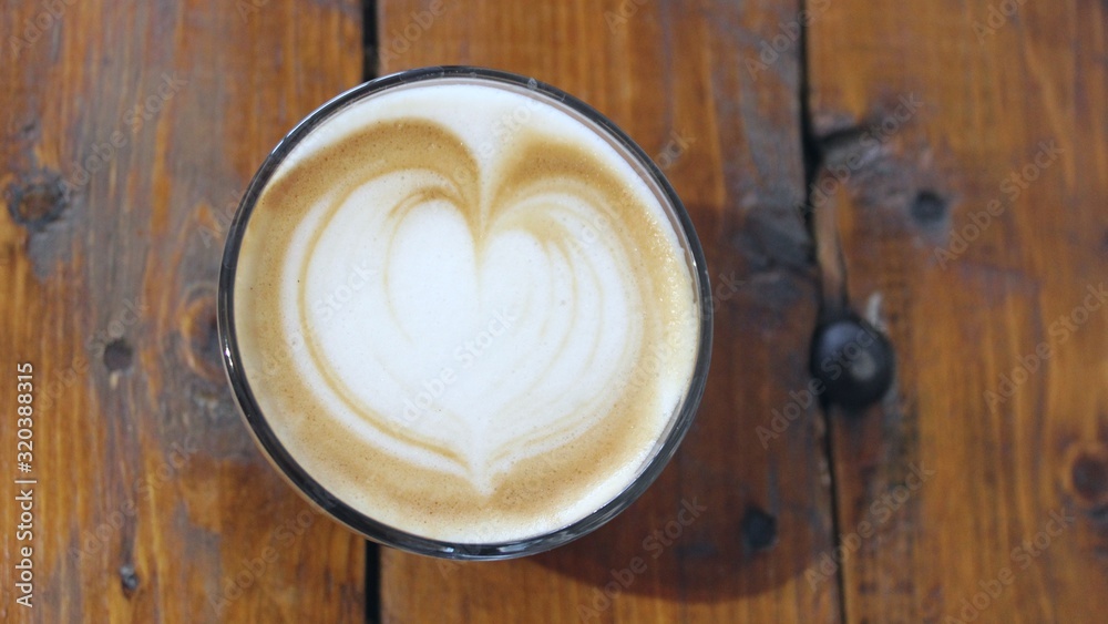 A cup of coffee with latte art, a cappuccino or a moka rich in caffeine with some milk, on the table in a trendy hipster cafe. A cup of coffee with latte art, a cappuccino or a moka rich in caffeine with some milk, on the table in a trendy hipster cafe.