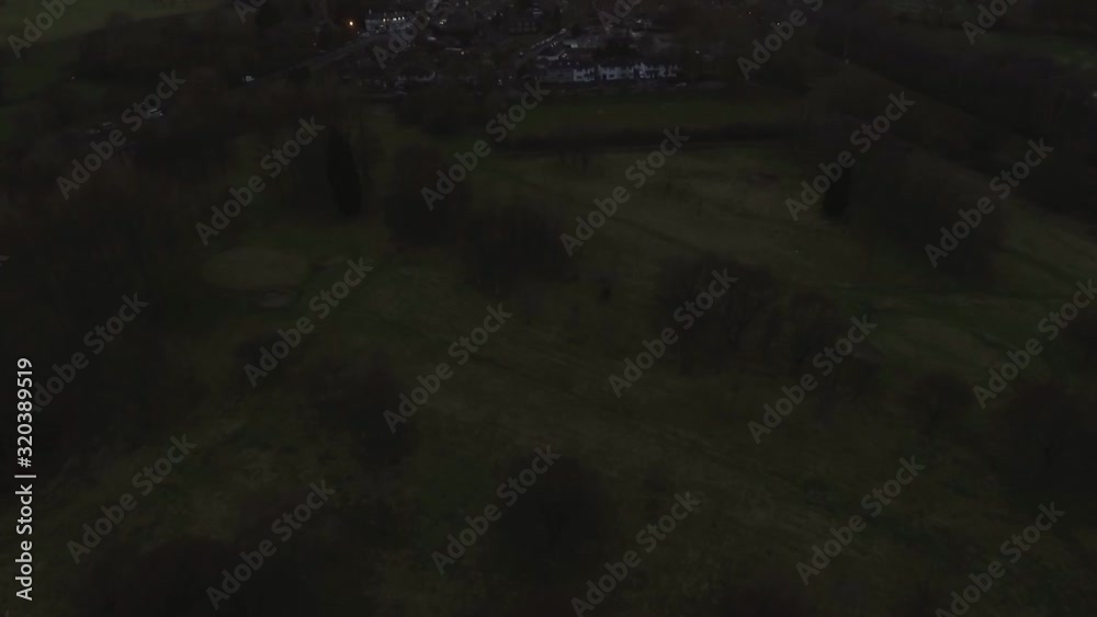 Aerial drone tilt shot to reveal vibrant orange sunset sunrise over small leafy English village Aerial drone tilt shot to reveal vibrant orange sunset sunrise over small leafy English village