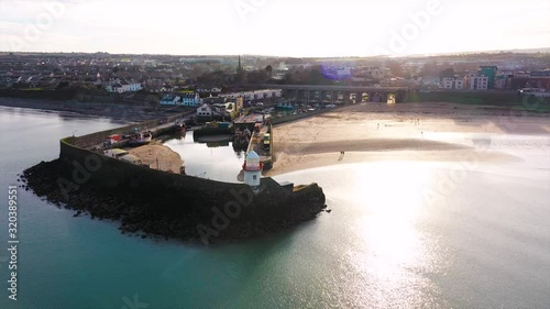 The White Lighthouse of Balbriggan. A beautiful sunny day in Ireland with a clam sea and few people walking around. photo